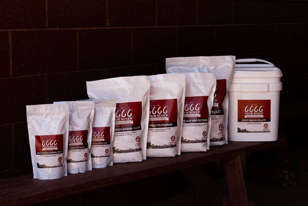 Assorted packages of 6666s supplements on a wooden surface with a dark brick wall background.